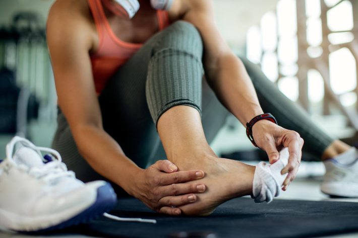 Dianella physio treating athletic woman’s injured foot after gym workout