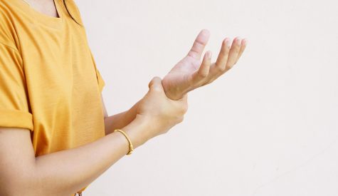 Woman with wrist pain from computer use receiving Noranda physiotherapy care
